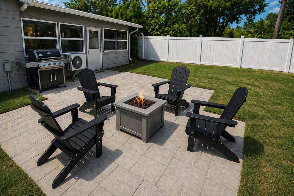 fully fenced backyard with grille, firepit, and loungers