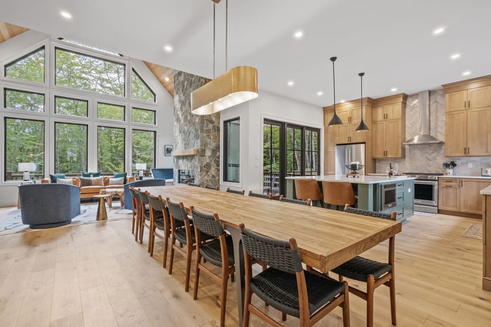 Spacious dining room featuring seating for 12, and large windows offering serene views. Perfect for entertaining or enjoying a fun dinner with the whole family. Pro tip: Ask us about our private chef option to take it up a notch - you deserve it! 
