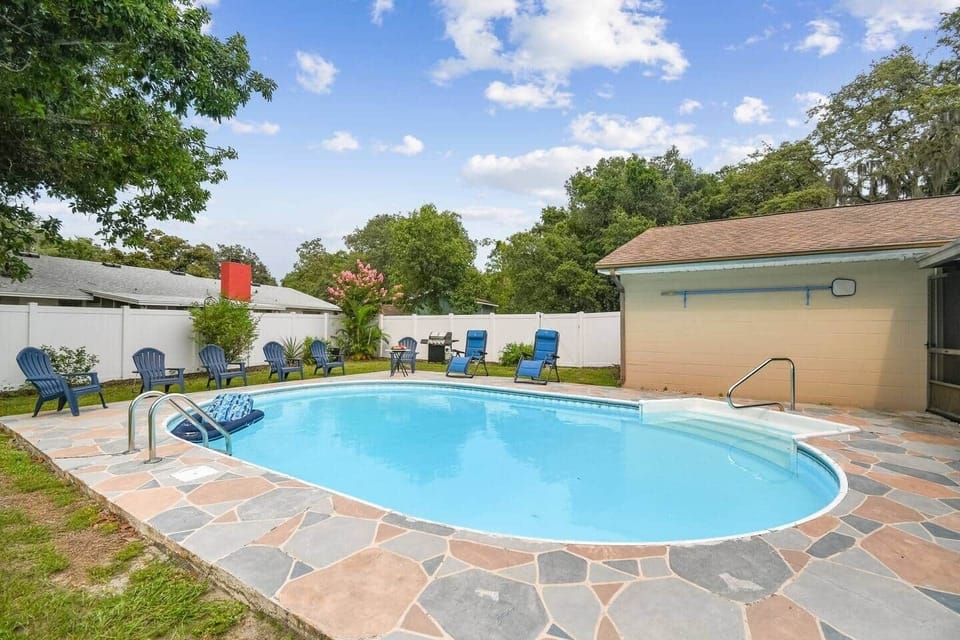 The pool area is fully fenced. Grill near the fence corner.