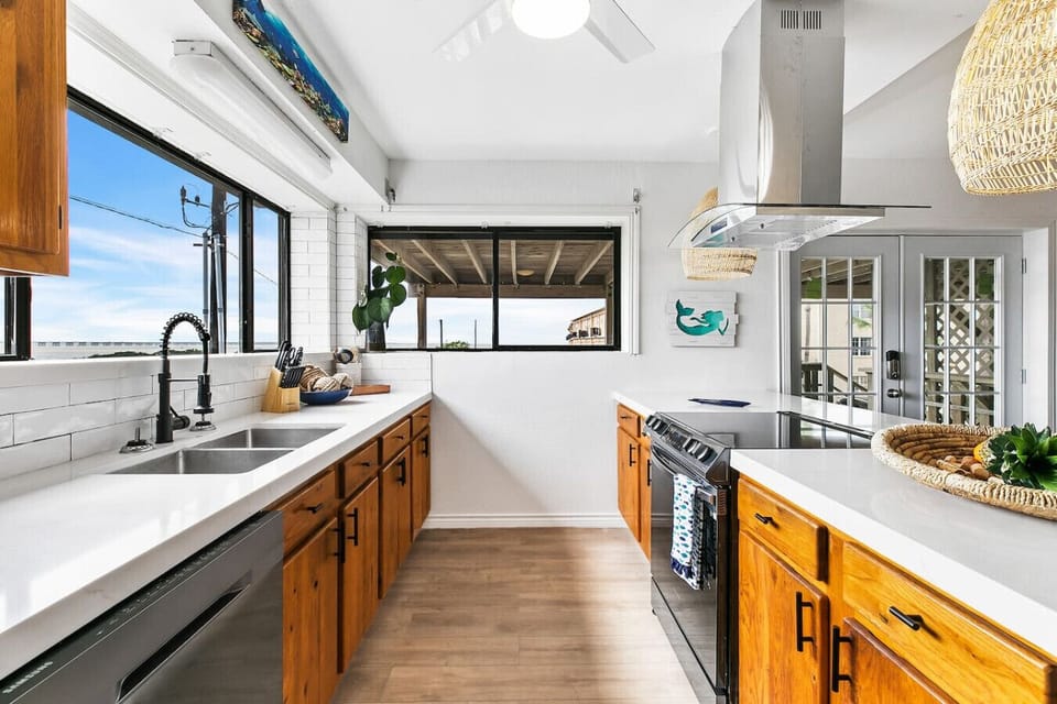 - Coastal kitchen with quartz countertops and ocean-view windows - Modern stainless appliances, island seating and bright natural light - Open concept beach condo perfect for vacation rental stays