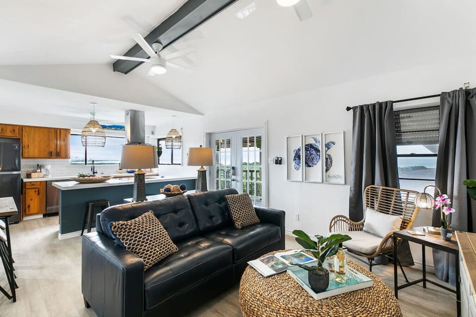 - Stylish open living room with vaulted ceilings and smart TV - Beach-inspired decor, cozy seating and natural textures - Bright waterfront condo steps from balcony views