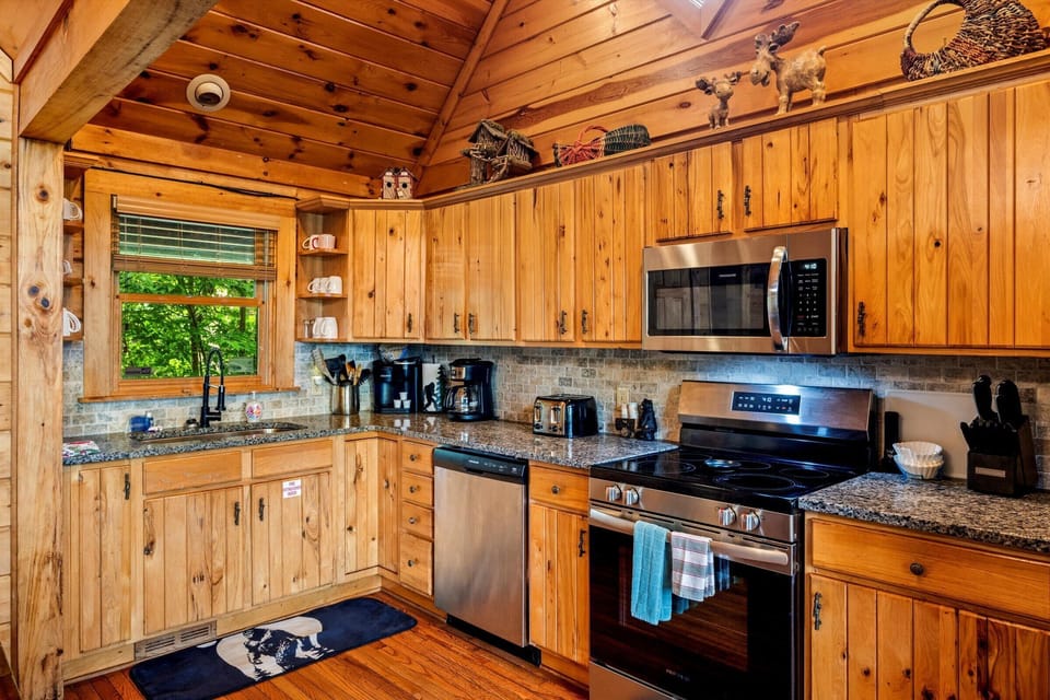 Modern kitchen fully equipped with a refrigerator, stove, oven, microwave, and dishwasher.