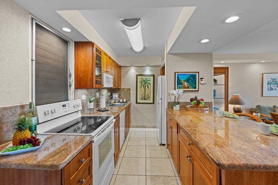 Fully equipped kitchen with full-sized appliances and sleek granite countertops—perfect for preparing island meals.