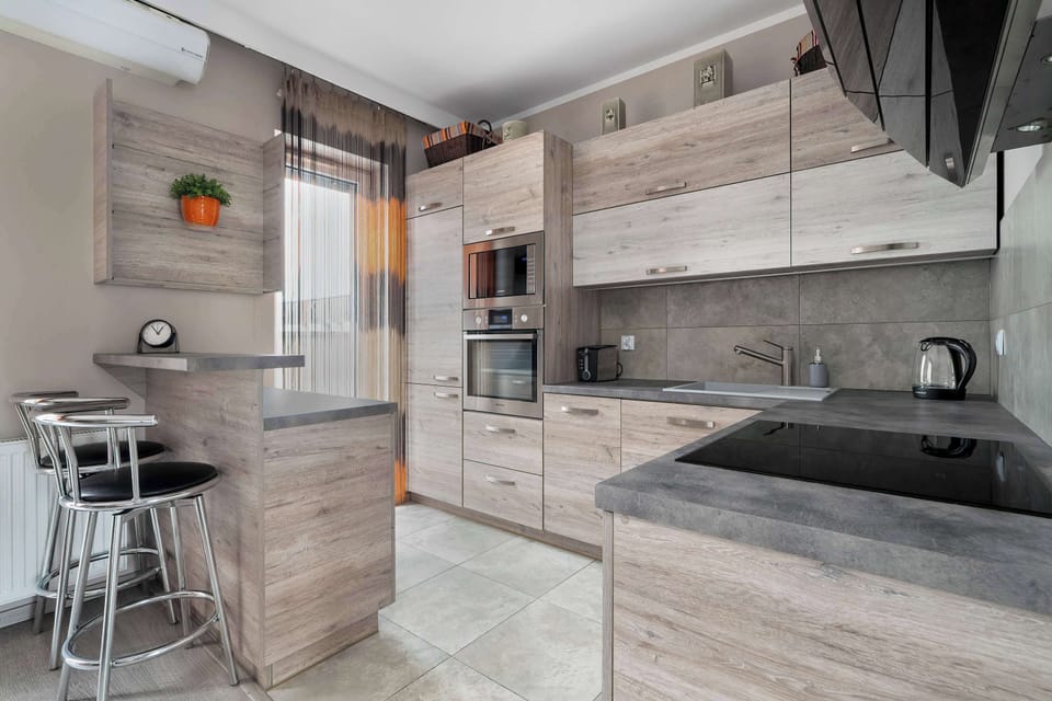 A modern kitchen with an island and high stools combines style with functionality, creating the perfect spot for coffee breaks.