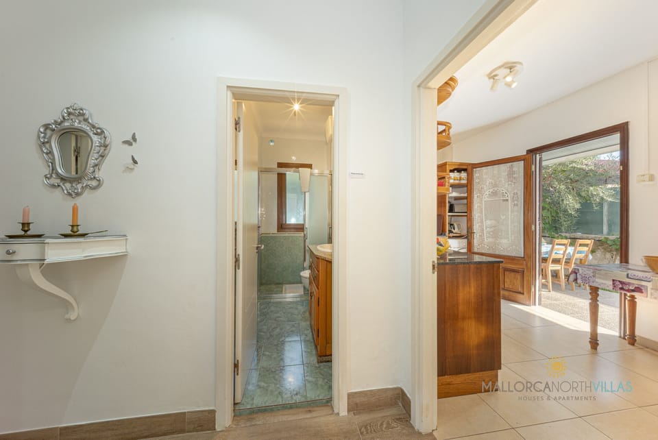 Hallway view at Casa Luna with direct access to the bathroom and kitchen-dining area, highlighting the practical and functional layout of the villa.