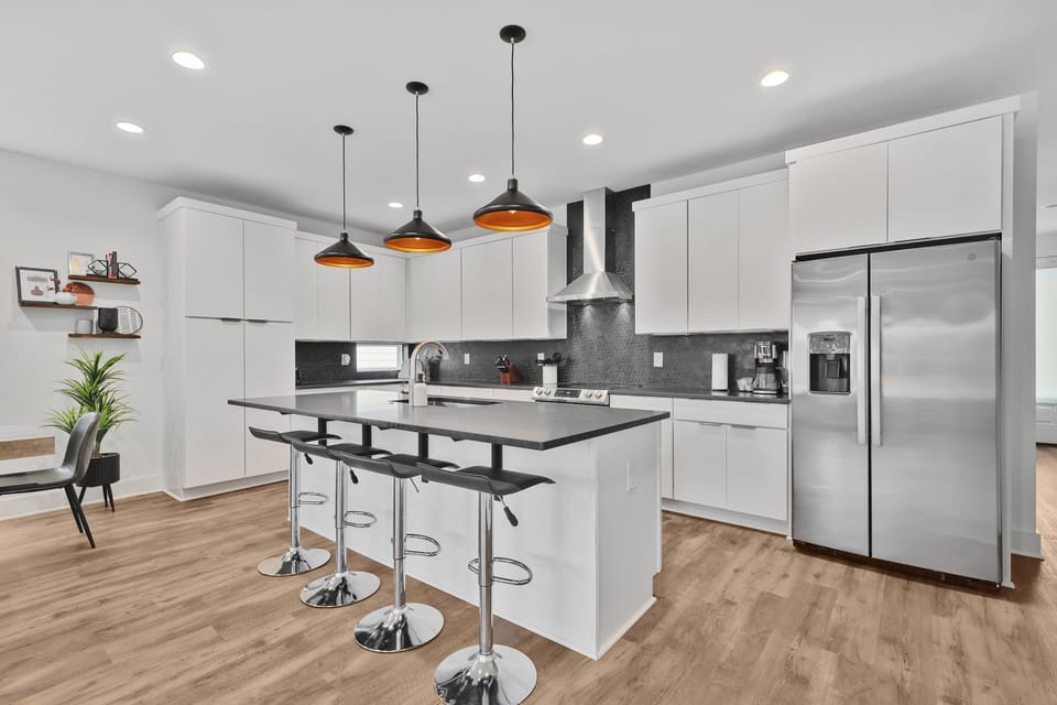 Spacious kitchen with bar stools and quartz island near Broadway