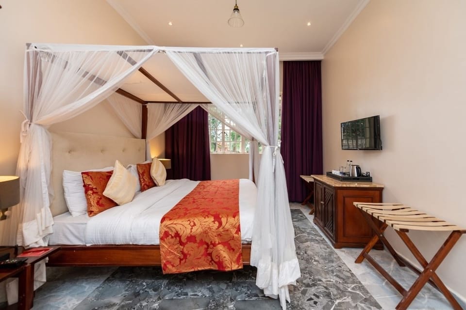 Unwind beneath a dreamy canopy bed with warm, elegant finishes.
