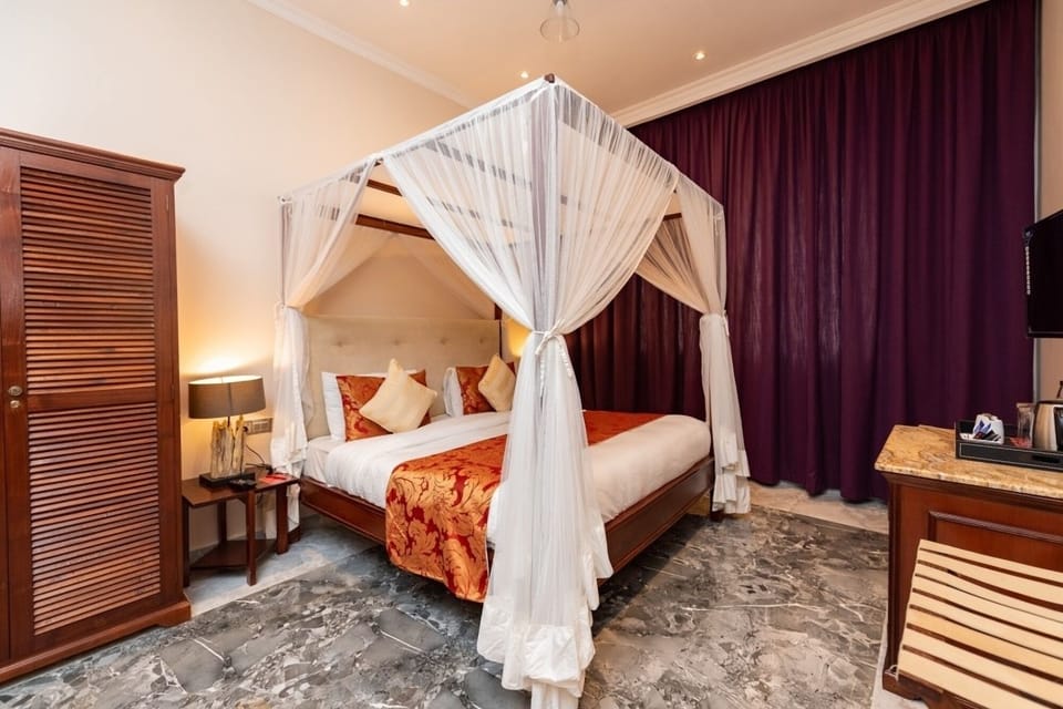 Indulge in a serene canopy bed framed by rich blackout drapes.