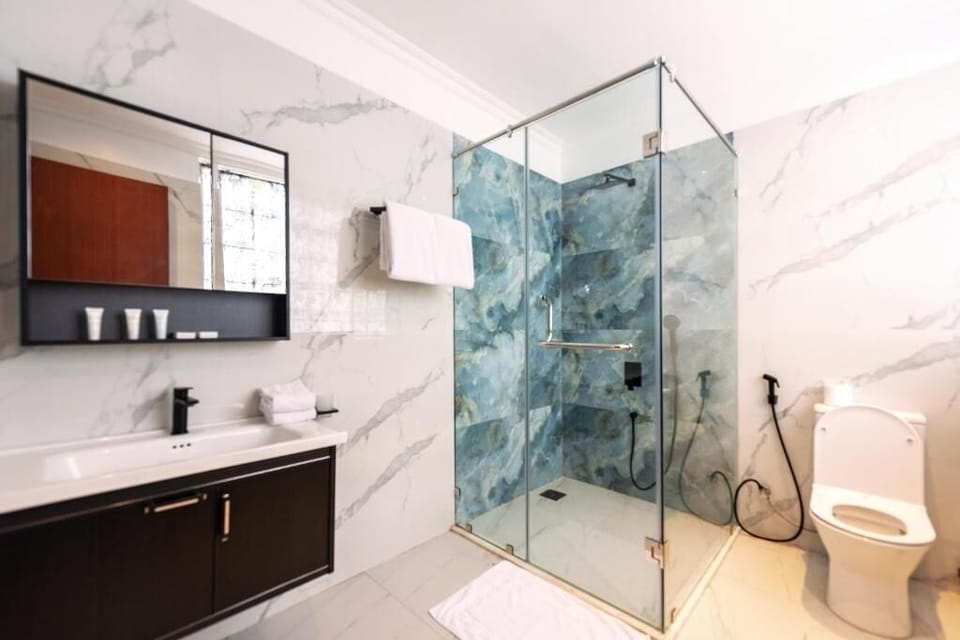 Refresh in a bright marble bath with a sleek glass shower.