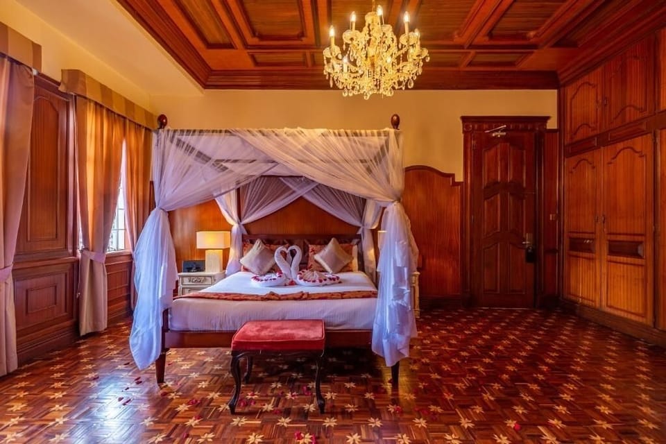Unwind beneath the romantic canopy in this grand wood-paneled suite.