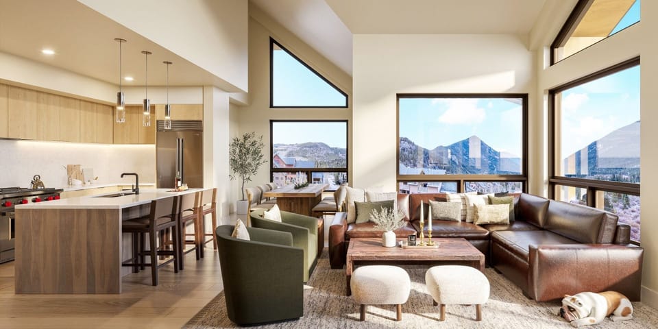 Open living space filled with natural light, where mountain views and a cozy fireplace create the perfect après-ski setting.