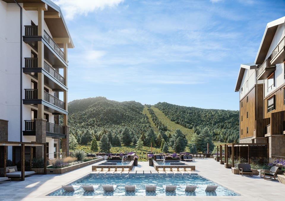 Relax by the sparkling pool while taking in sweeping slope side mountain views under the open sky.