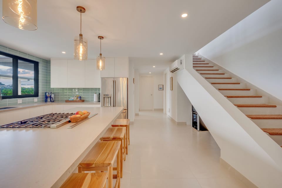 Kitchen island and stairs — elegant design, now enhanced by a bar below.