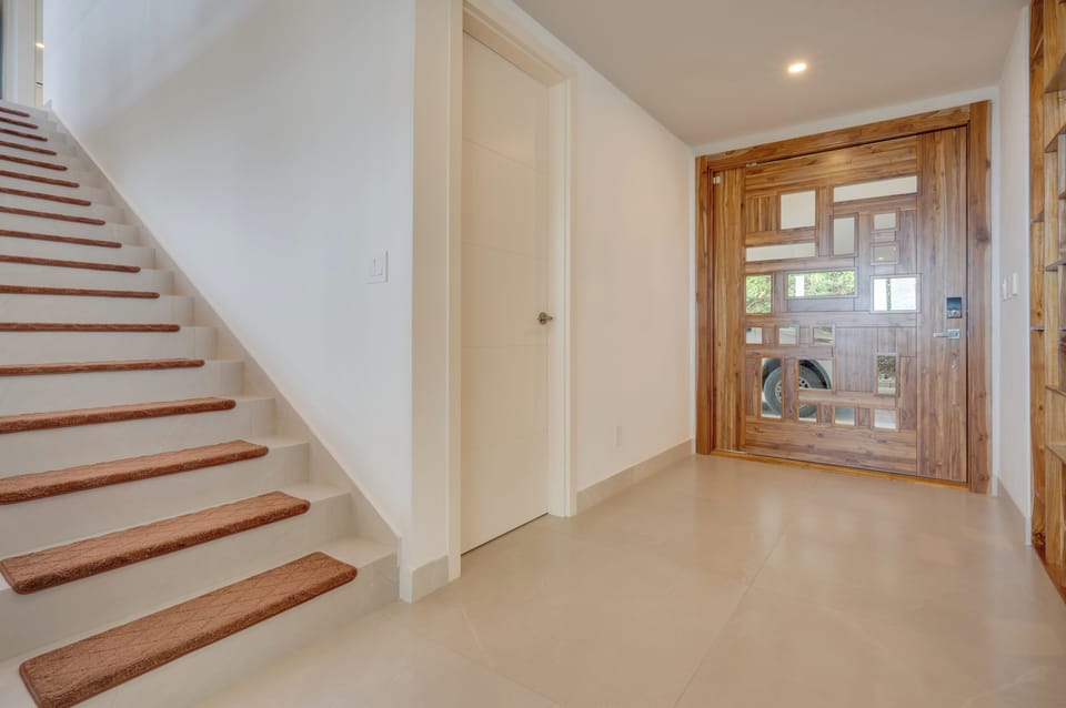 Where teak, light & design meet — the artful heart of The Pinnacle’s entry.