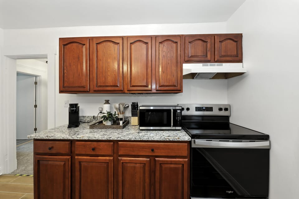 full kitchen with cookware, microwave and oven