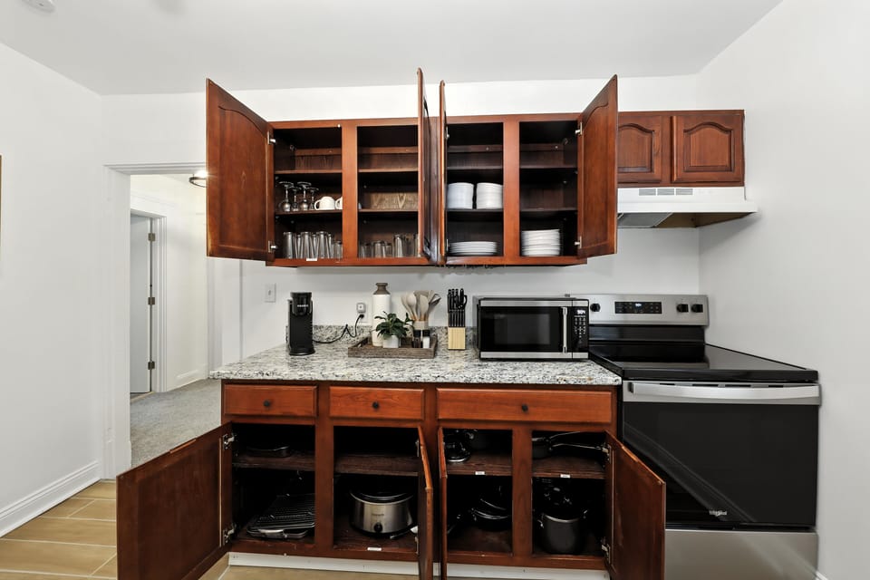 full kitchen with cookware, microwave and oven