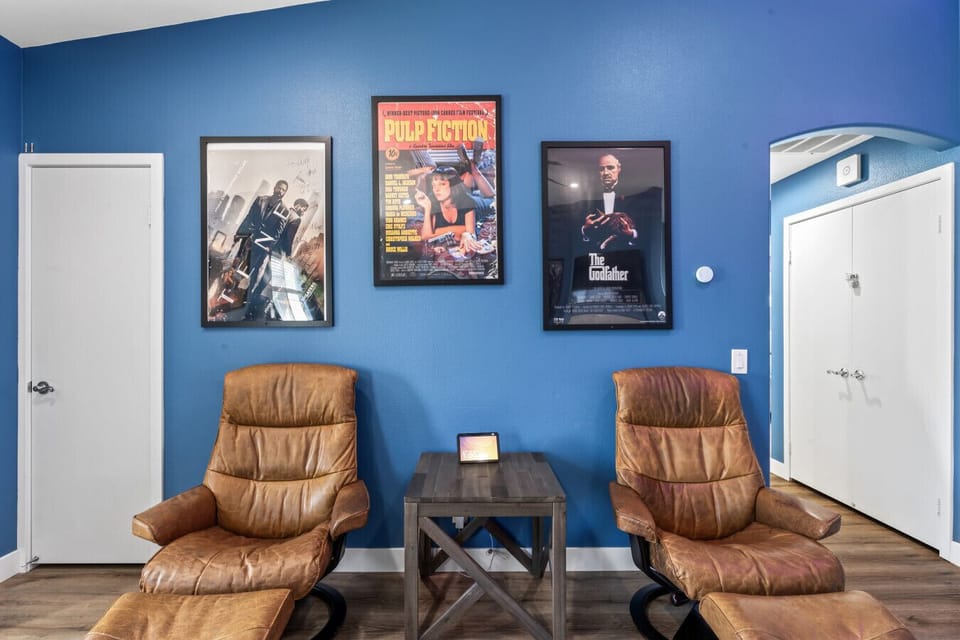 Theater-inspired seating area w/ movie posters & soft lighting for chill nights in.