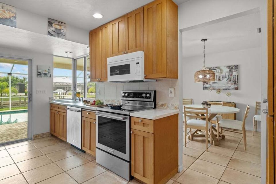 Fully equipped kitchen with poolside and canal views, making cooking a pleasure