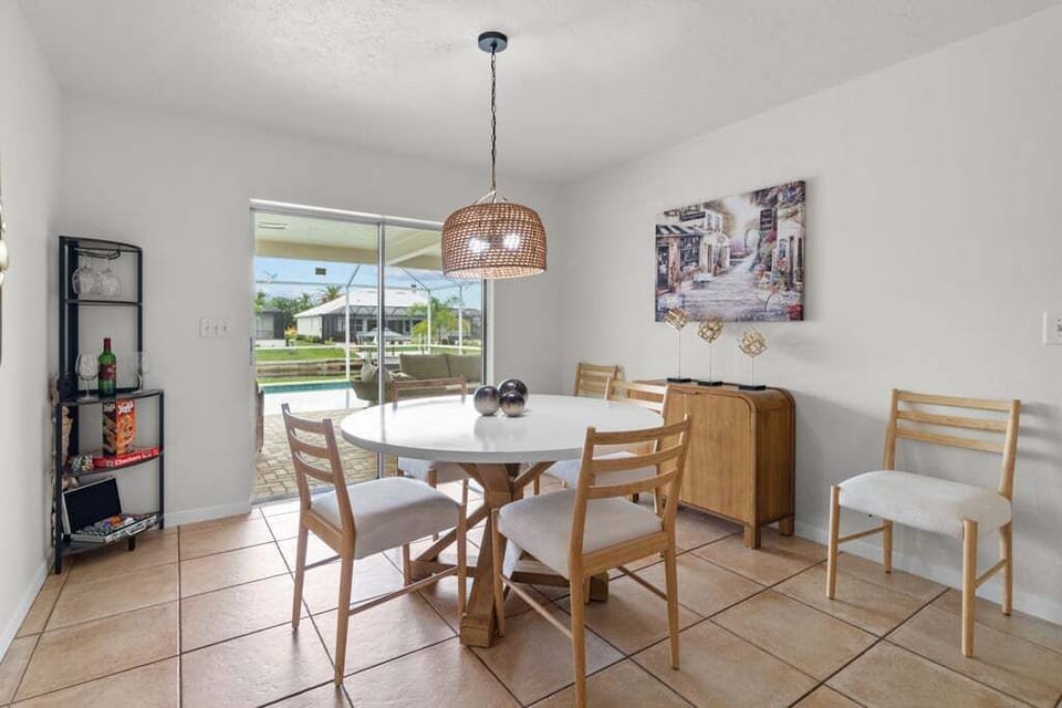 Dining area with pool and waterfront views, perfect for family meals or morning coffee.