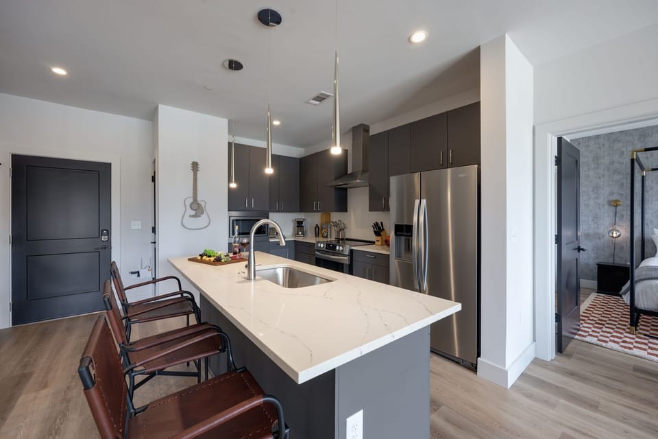 Unit 1: Fully equipped kitchen with brand-new stainless-steel appliances and a Kitchen island that offers ample counter space and bar seating.