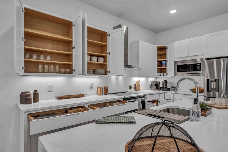 Cook and gather in this modern kitchen featuring sleek finishes, spacious countertops, and warm wood accents for a welcoming touch.