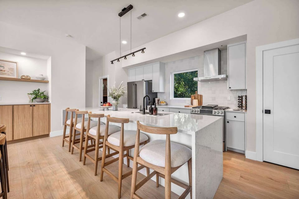 Bright, open kitchen with a large island and bar seating creates the perfect spot for morning coffee, shared meals, and conversation.