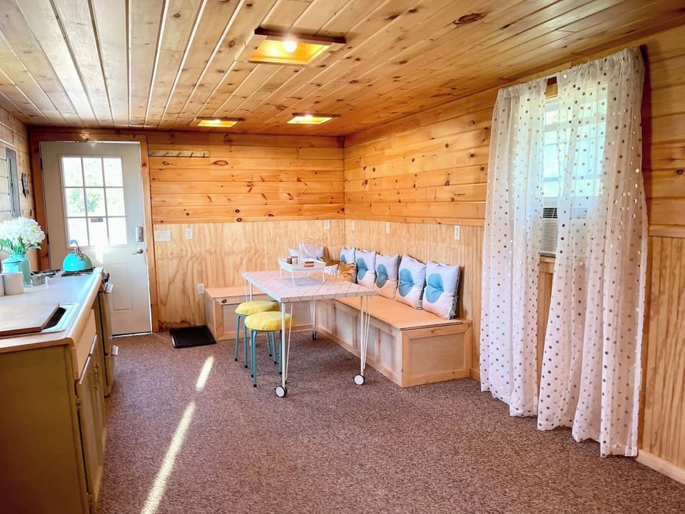 Spacious open-plan living and dining area with a versatile table on wheels, perfect for meals, games, or rearranging for extra space. Designed for comfort and flexibility during your stay.