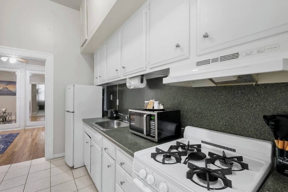 Stylish kitchen with a sleek design, complete with cookware and utensils for your convenience.