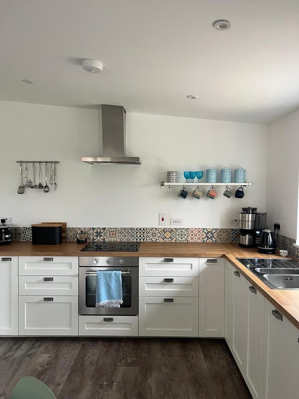 Kitchen area with coffee maker, oven, hob, dishwasher and microwave.