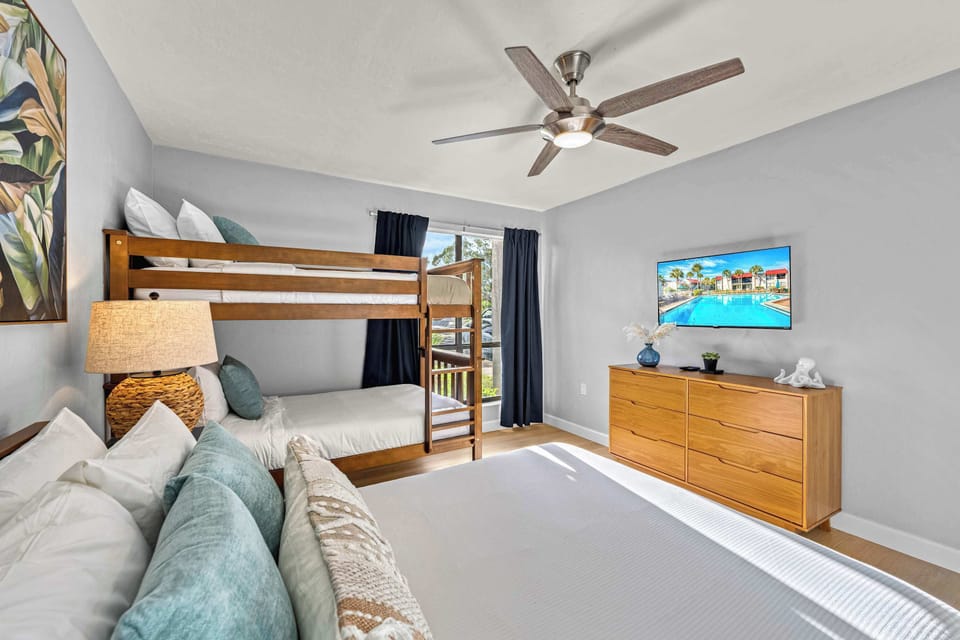 Family-friendly guest bedroom with full bed, matching twin bunks, and a Smart TV – sleep under the island breeze in comfort.