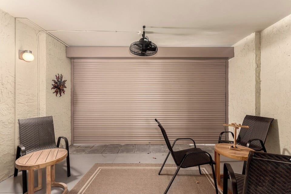 Patio with electric roll down door. Seating, ceiling fan for your enjoyment.