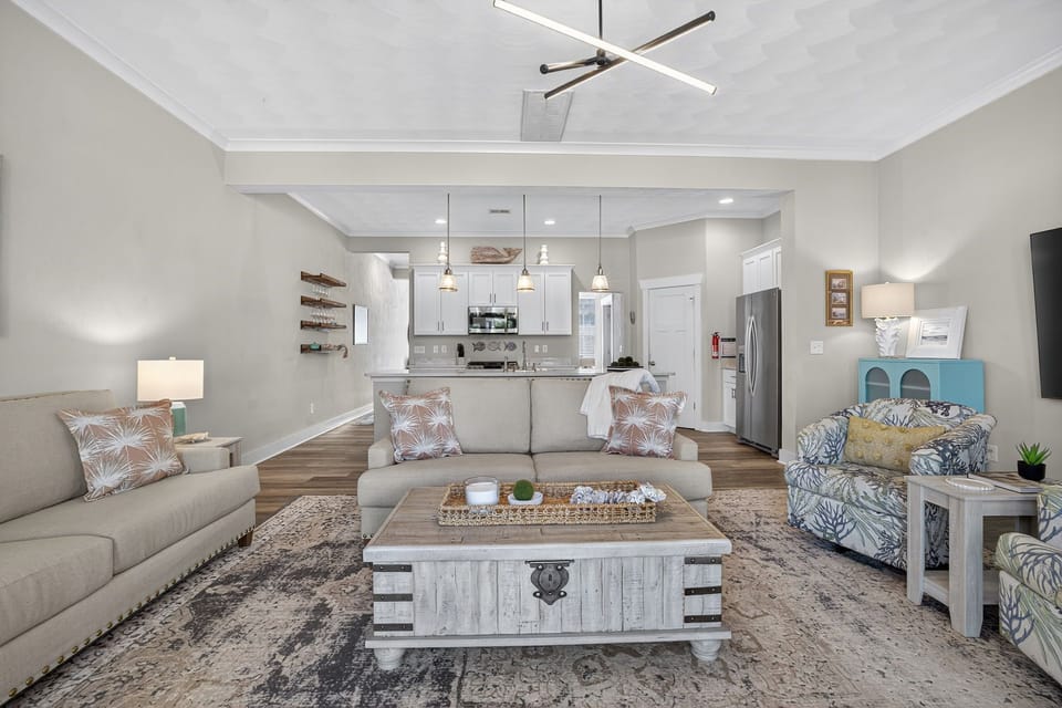 Living area and Open concept, fully stocked kitchen. The stools are just behind the sofa, which are nestled up to the bar for visitation perfection.