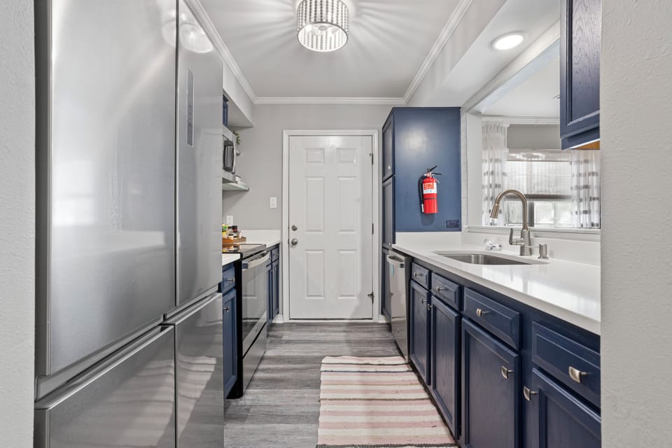 Fully stocked galley kitchen leads to outdoor private patio with grill.