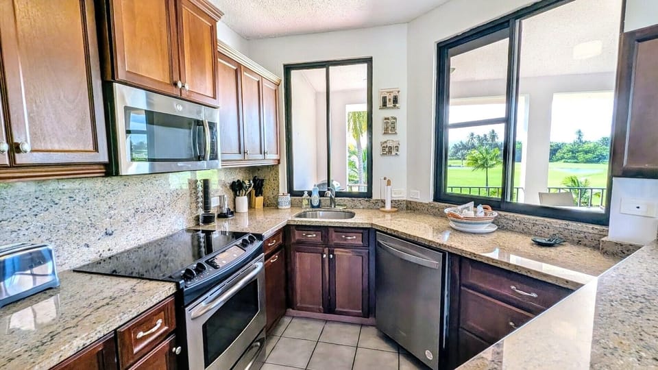 Modern kitchen with golf course view, full amenities, and sleek finishes.
