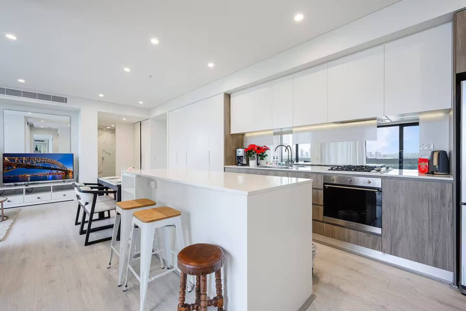 Modern kitchen with island bench, bar stools, and full cooking facilities.
