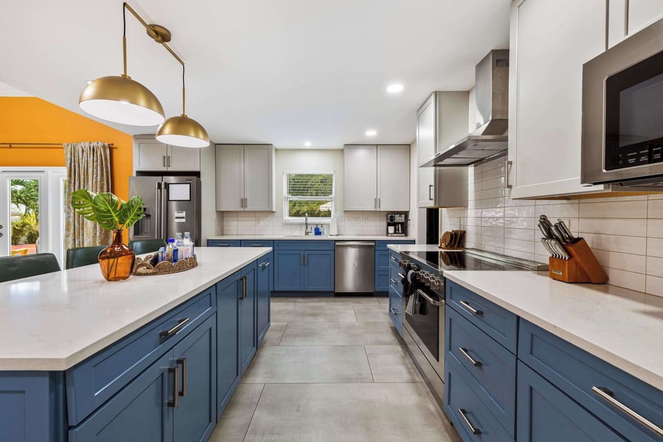 Whip up a feast in this stunning chef's kitchen! Sleek blue cabinetry, gold accents, and all the space you need to cook, gather, and celebrate together.