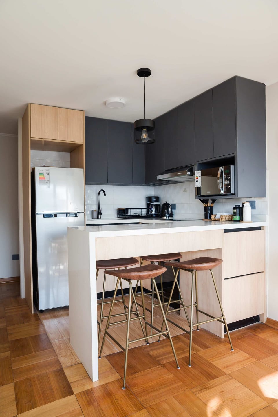 Sleek and modern kitchen with stylish bar seating, perfect for enjoying a cozy meal or morning coffee.