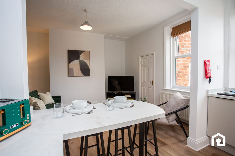 Peaceful sleeping space with a neatly prepared bed, open wardrobe, and modern vanity