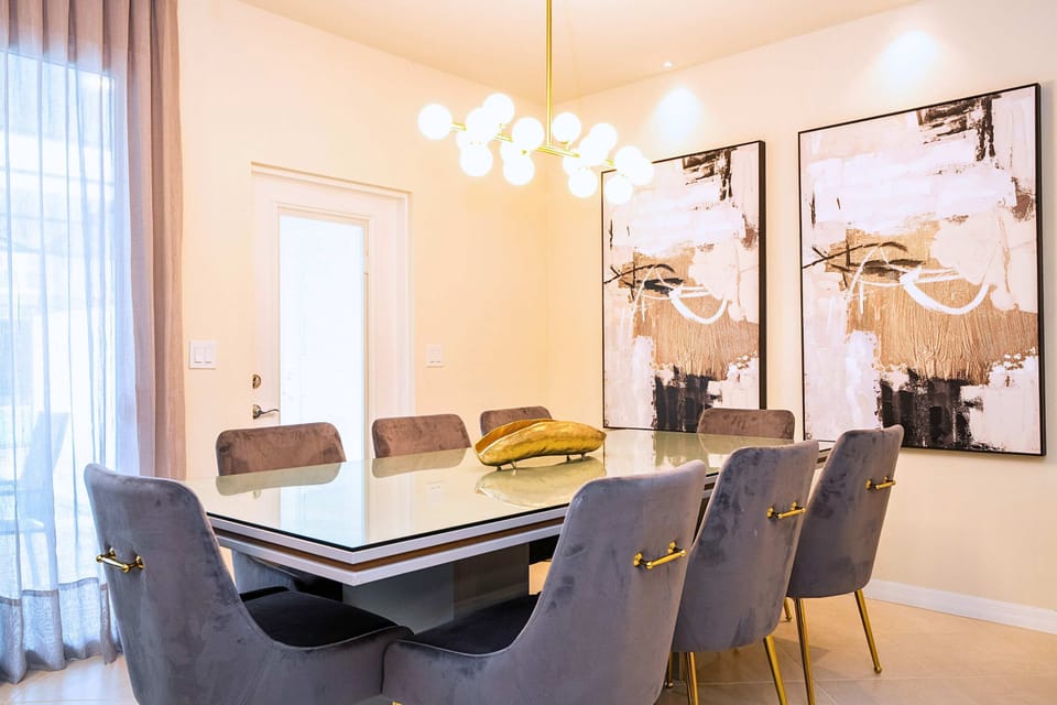 Enjoy meals in this chic dining nook, where elegant wall frames and a hanging chandelier bring character and warmth to the space