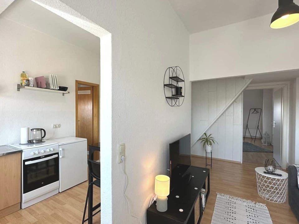 Die offene kleine Küche mit Herd, Kühlschrank und allem Notwendigen bietet dir die perfekte Möglichkeit, auch im Urlaub in Wilhelmshaven unkompliziert selbst zu kochen und dich wie zuhause zu fühlen.