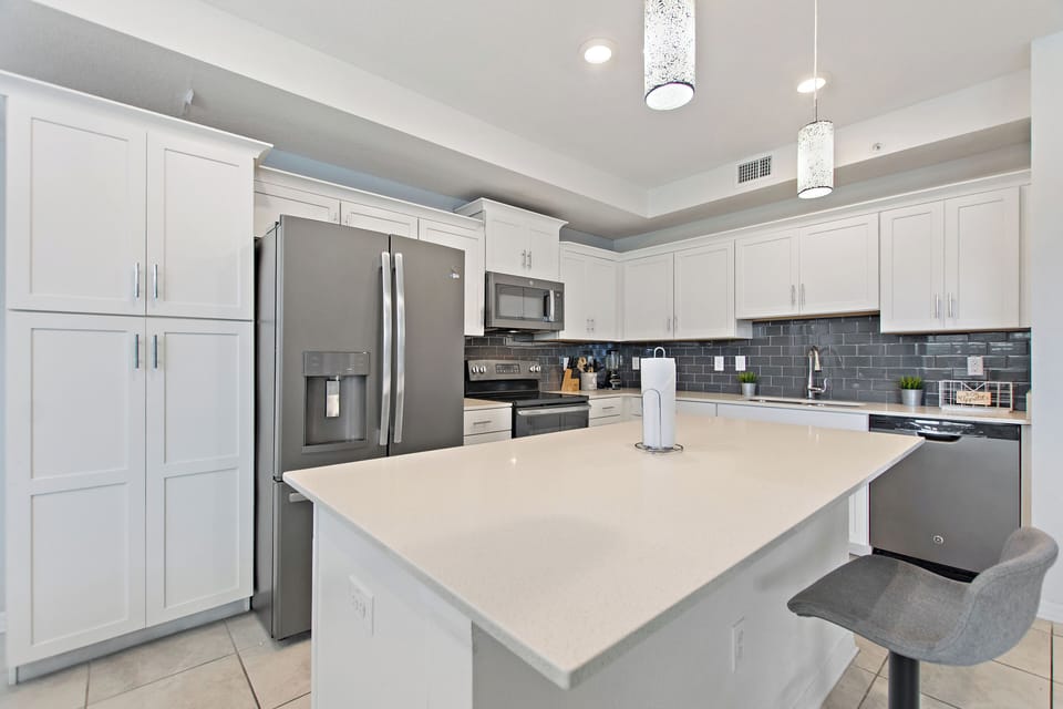 Modern kitchen with large island, pendant lighting and stainless-steel appliances near Disney – Shine Villas | Sunset Retreat, Storey Lake Resort, Orlando