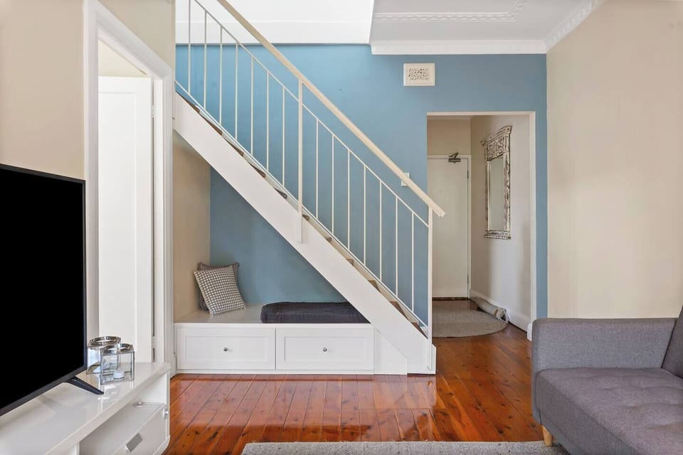Built-in bench seating under the stairs offers a cosy reading nook for kids.