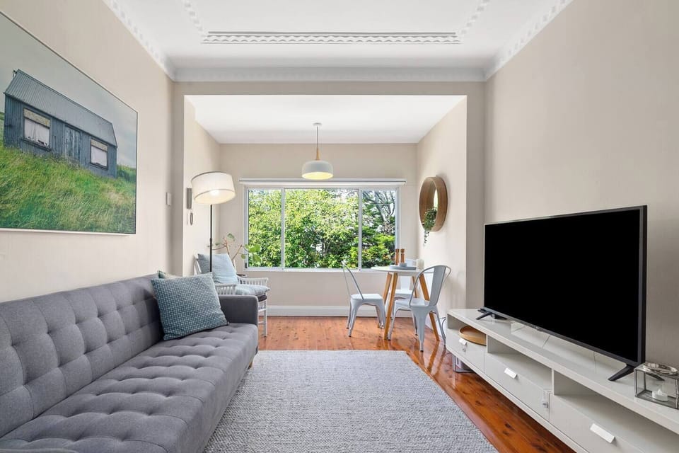 Bathed in natural light with serene treetop views, the living area invites you to unwind on the plush sofa or enjoy slow moments by the sunlit dining nook.