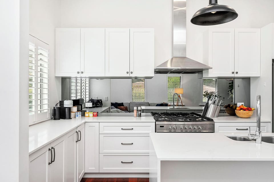 Modern kitchen with white cabinets, gas range, and essentials.