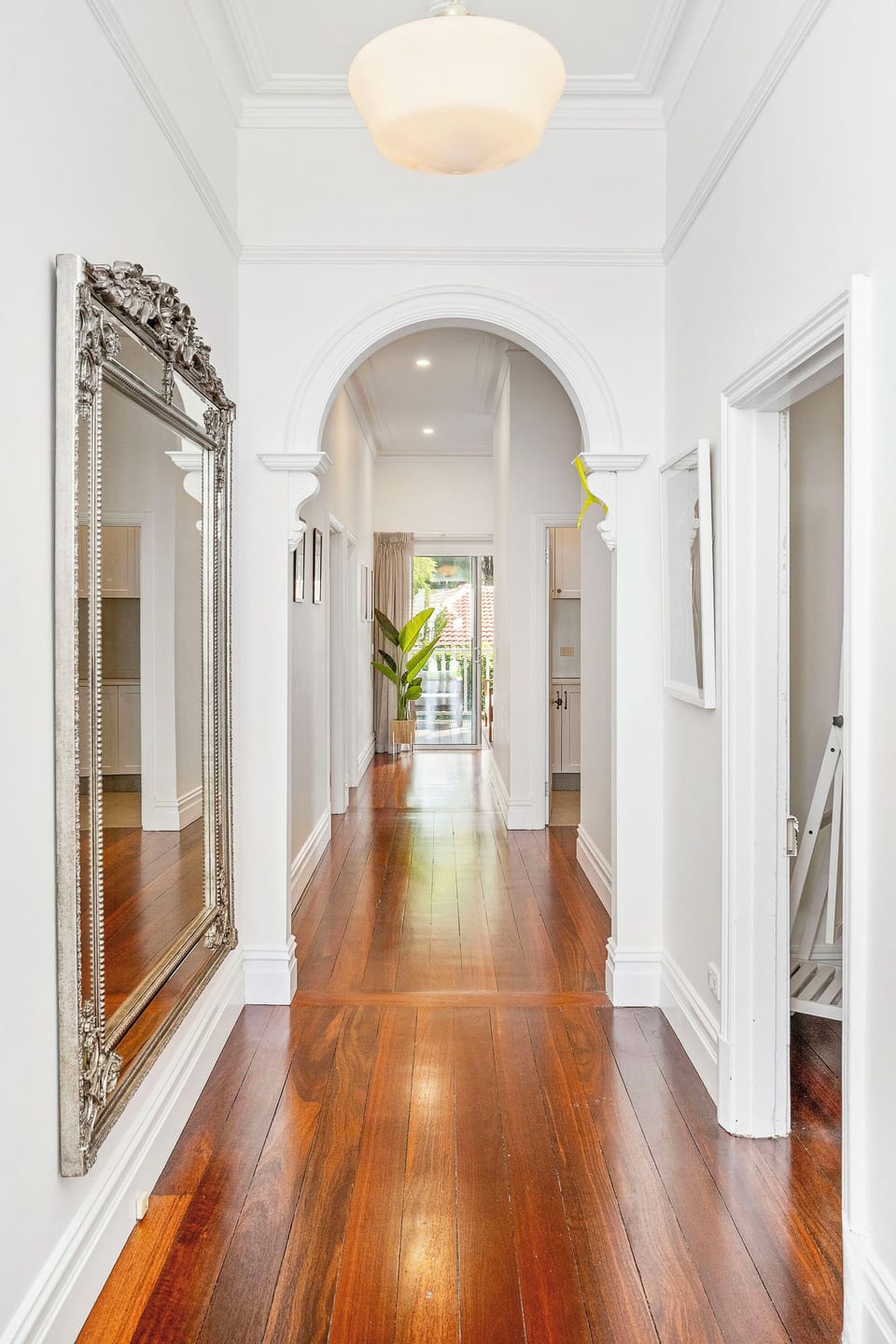 Step into elegance with hardwood floors leading to a bright doorway.