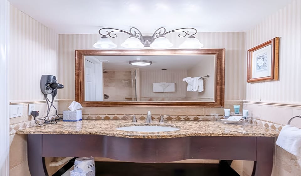 Refresh at the spacious vanity with warm lighting and storage.