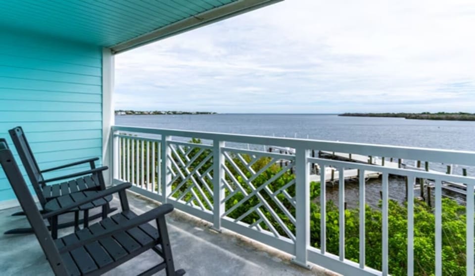 Sip morning coffee on the balcony overlooking calm bay waters.