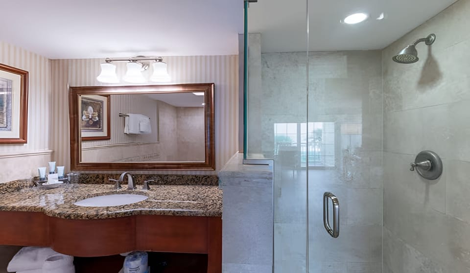 Rinse off sand under a sleek glass shower and warm lighting.