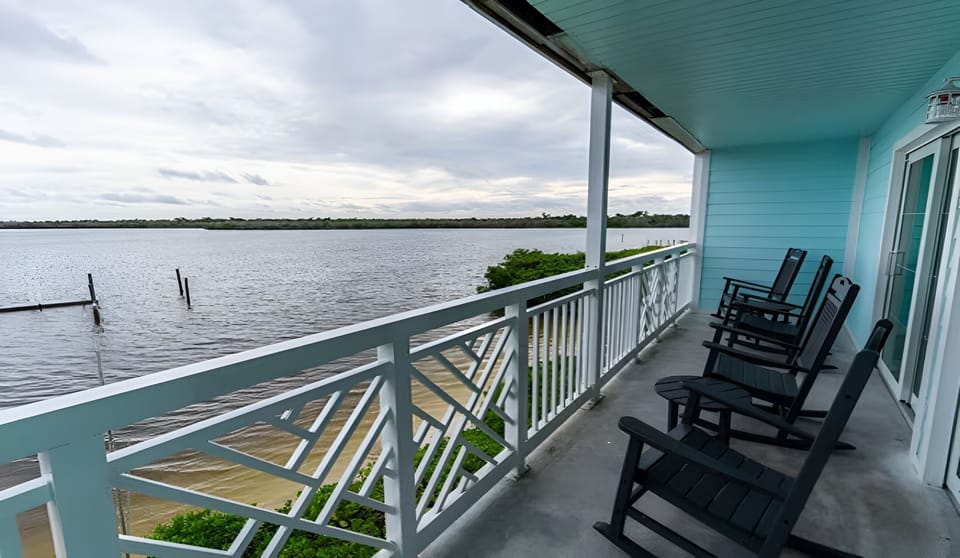Unwind in rocking chairs as sunset colors soften the horizon.