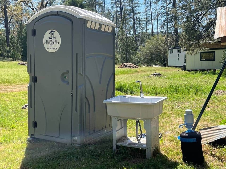 Utility sink and porta potty. To the right is well water that will be heated. By the sun for your showers. 